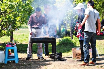 5月2日,昌平沙河水库,水坝南端东侧公园里,游客们露天烧烤。新京报记者 尹亚飞 摄
