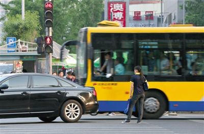 5月9日,朝阳路,一位闯红灯的市民被穿过路口的汽车“截停”在斑马线上。新京报记者 薛珺 摄