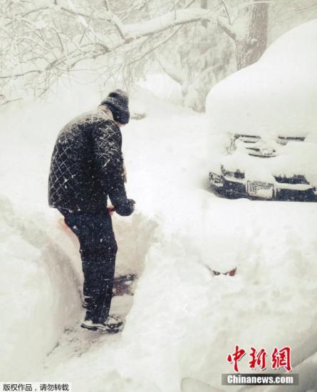 资料图：当地时间11月18日，美国东北部地区遭遇大雪袭击，纽约州气温聚降，伊利湖出现大湖效应。图为纽约市民在清除积雪。